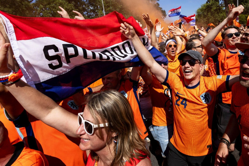 Berlin, Germany. 25th June, 2024. Soccer, UEFA Euro 2024, European Championship, Netherlands - Austria, preliminary round, Group D, matchday 3. Dutch fans celebrate before the match. They walk in a fan march to the Olympiastadion Berlin. Credit: Carsten K