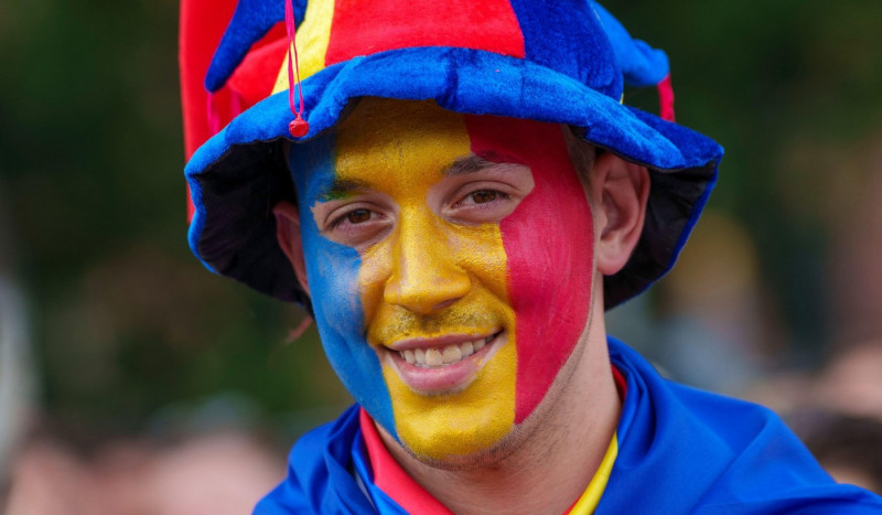 26 June 2024, Hesse, Frankfurt/Main: Soccer, UEFA Euro 2024, European Championship, Slovakia - Romania, preliminary round, Group E, match day 3: A Romanian fan has painted himself in the national colors. The fan zone was cleared at the end of the first ha
