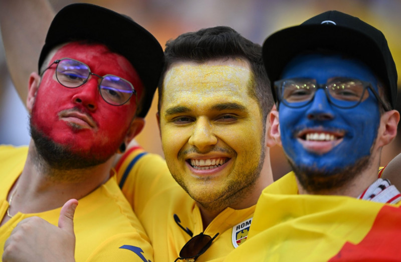 26 June 2024, Hesse, Frankfurt/M.: Soccer, UEFA Euro 2024, European Championship, Slovakia - Romania, Preliminary round, Group E, Matchday 3, Frankfurt Arena, Romanian fans with colorful faces stand in the stands. Photo: Arne Dedert/dpa