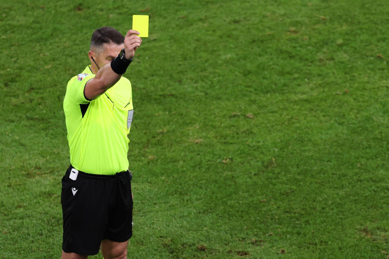 Hamburg, Germany. 26th June, 2024. Soccer: Football, UEFA Euro 2024, European Championship, Czech Republic - Turkey, Preliminary round, Group F, Matchday 3, Volksparkstadion Hamburg, Referee Istvan Kovacs from Romania shows a yellow card. Credit: Jens Btt