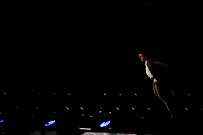 Tom Cruise, accroché à un fil, descend du toit du stade de France pour prendre le drapeau olympique