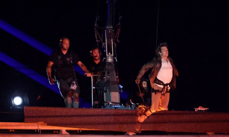 Tom Cruise, accroché à un fil, descend du toit du stade de France pour prendre le drapeau olympique