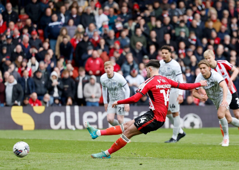 Lincoln City's Daniel Mandroiu slips as he takes his spot kick during the Sky Bet League One match at the LNER Stadium, Lincoln. Picture date: Saturday April 27, 2024.