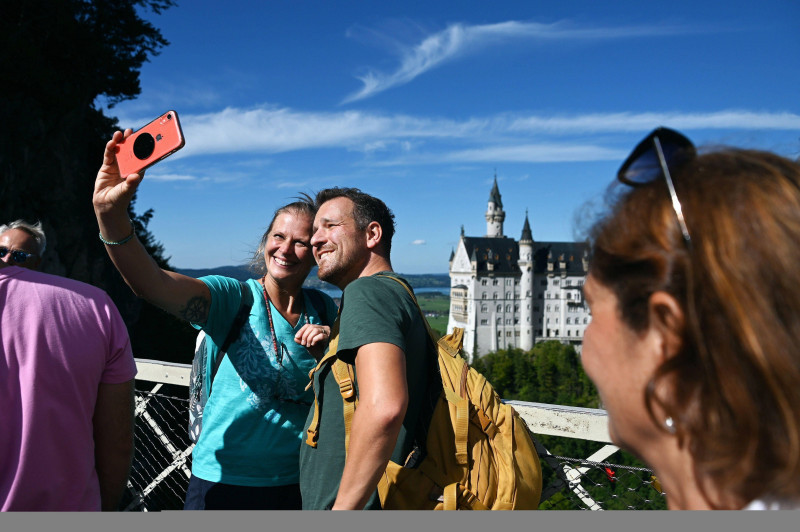 Touristen machen ein Selfie mit Schloss Neuschwanstein im bayerischen Allgu bei Fssen, Deutschland *** Tourists take a selfie with Neuschwanstein Castle in Bavarian Allgu near Fssen, Germany