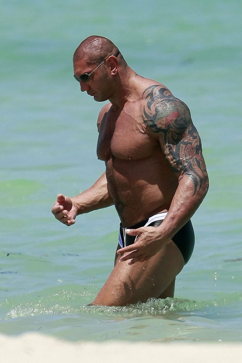 WWE star Dave Batista shows off his tattoos as he relaxes on South Beach in Florida