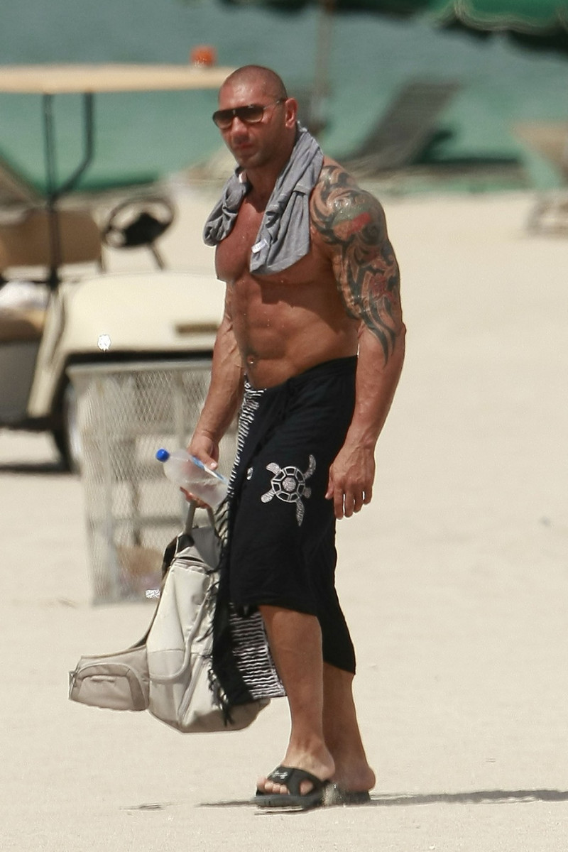 WWE star Dave Batista shows off his tattoos as he relaxes on South Beach in Florida