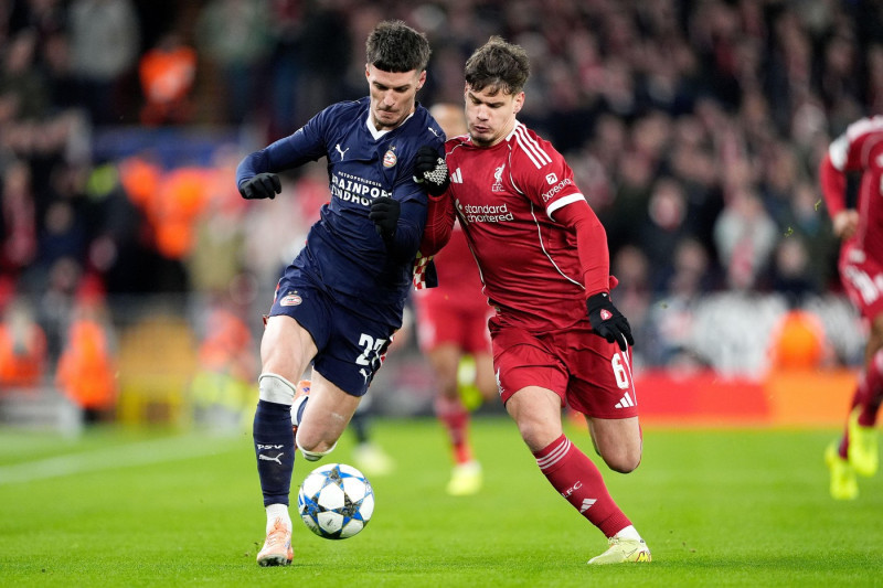PSV Eindhoven's Dennis Man (left) and Liverpool's Milos Kerkez battle for the ball during the UEFA Champions League, league phase match at Anfield, Liverpool. Picture date: Wednesday November 26, 2025.