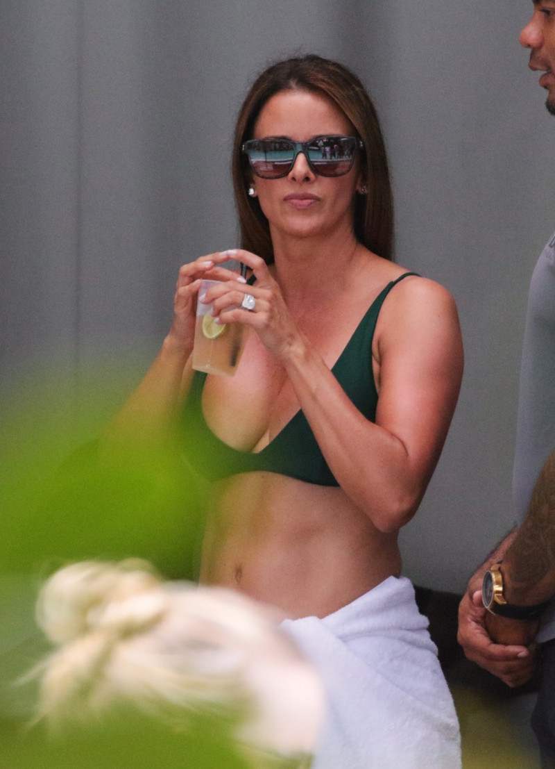EXCLUSIVE: Michael Jordan smokes a cigar while his wife dancings in a green bikini at a pool party in Miami