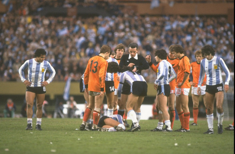 Gonella, the referee of Italy looks at his watch as an Argentinan player lies injured on the ground