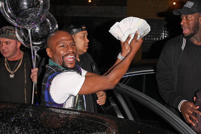 EXCLUSIVE: Promoter Floyd Mayweather flashes his money as he leaves TAO restaurant with his entourage