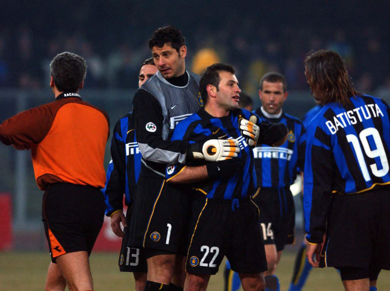 Buruk Okan of Inter Milan is restrained by team-mates after he was sent off
