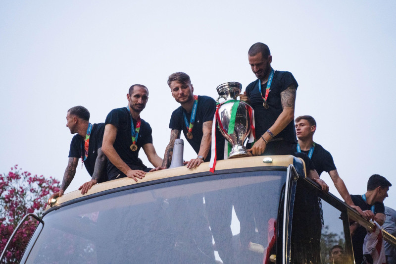 ROME, ITALY - JULY 12, 2021. Federico Bernardeschi, Giorgio Chiellini, Ciro Immobile and Leonardo Bonucci of the Italian national team celebrate the victory at Euro 2020 by exhibiting the European Cup from an open bus with a tour in the center of Rome. Cr