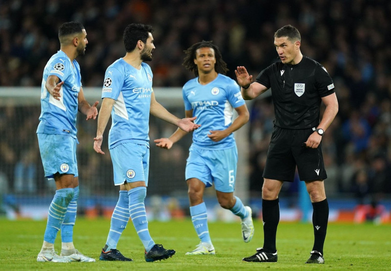 Referee Istvan Kovacs speaks to the Manchester City players during the UEFA Champions League Quarter Final first leg match at the Etihad Stadium, Manchester. Picture date: Tuesday April 5, 2022.
