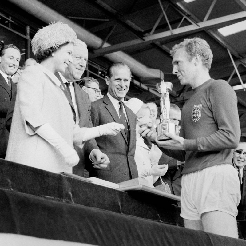 File photo dated 30/07/1966 of England captain Bobby Moore holds the Jules Rimet Trophy, collected from the Queen Elizabeth II, after leading his team to a 4-2 victory over West Germany, in an exciting World Cup Final that went to extra time at Wembley, L