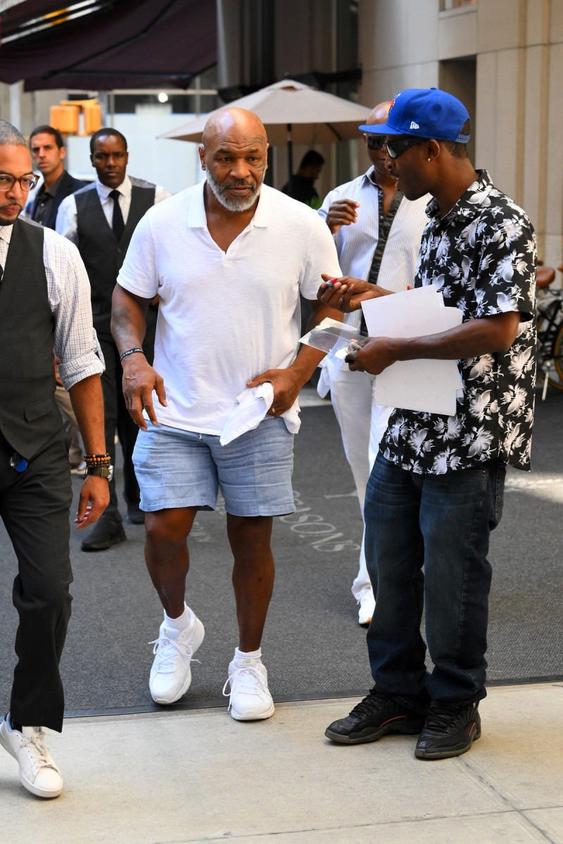 Mike Tyson all smiles while signing autographs for his fans while leaving his New York City Hotel