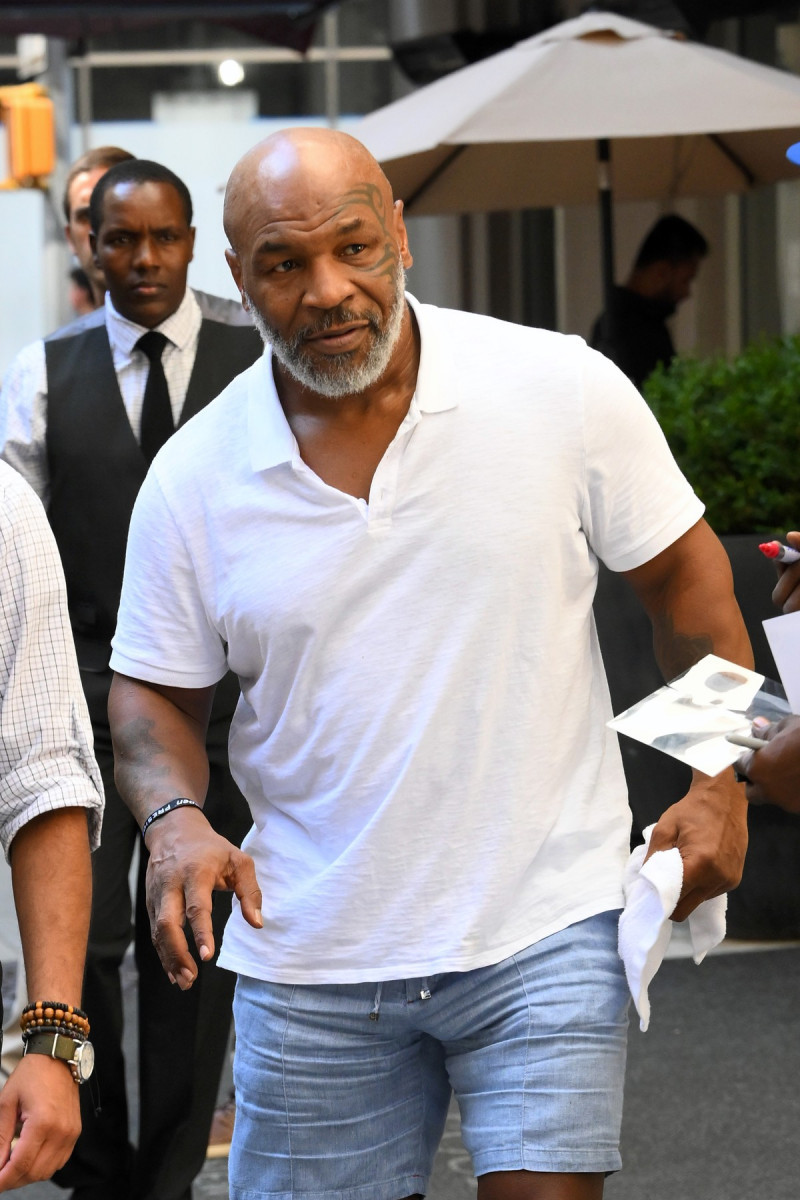 Mike Tyson all smiles while signing autographs for his fans while leaving his New York City Hotel