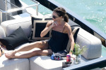 Victoria Beckham seems to have bit of a wardrobe malfunction in her mini dress as she sits awkwardly on her yacht with David Beckham and family in Miami