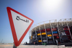 Doha, Qatar. 30th Mar, 2022. A traffic sign in Arabic stands next to Stadium 974 during a Fifa media tour. For the construction of the stadium 974 colorfully arranged shipping containers were used. Doha will host the Fifa Congress on March 31 and the draw
