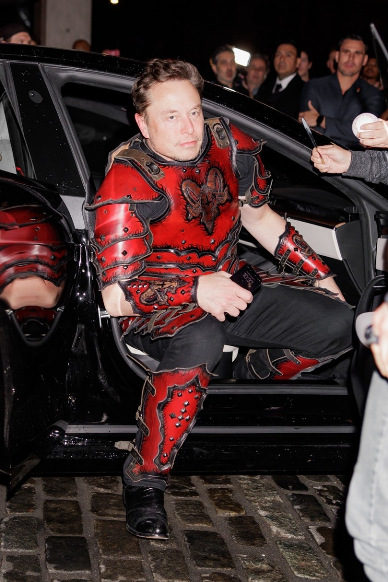 Elon Musk wears a knight costume with an upside-down cross on the back as he arrives at Heidi Klum’s Halloween party in NYC