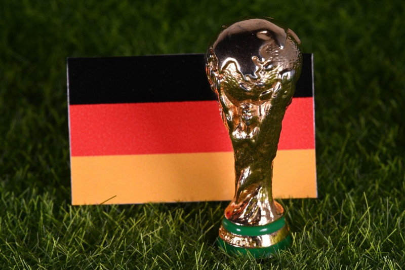 November 13, 2022, Doha, Qatar. The FIFA World Cup trophy on the background of the flag of Germany on the green lawn of the stadium.