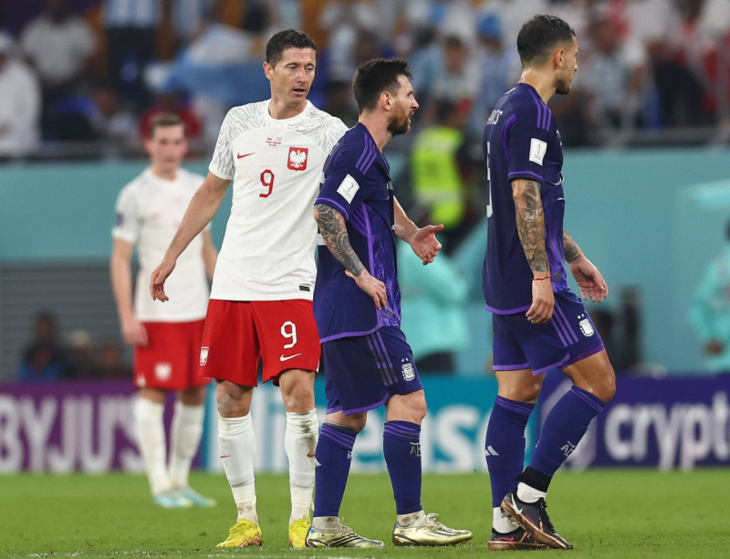Doha, Qatar, 30th November 2022. Robert Lewandowski of Poland apologises and is ignored by Lionel Messi of Argentina du
