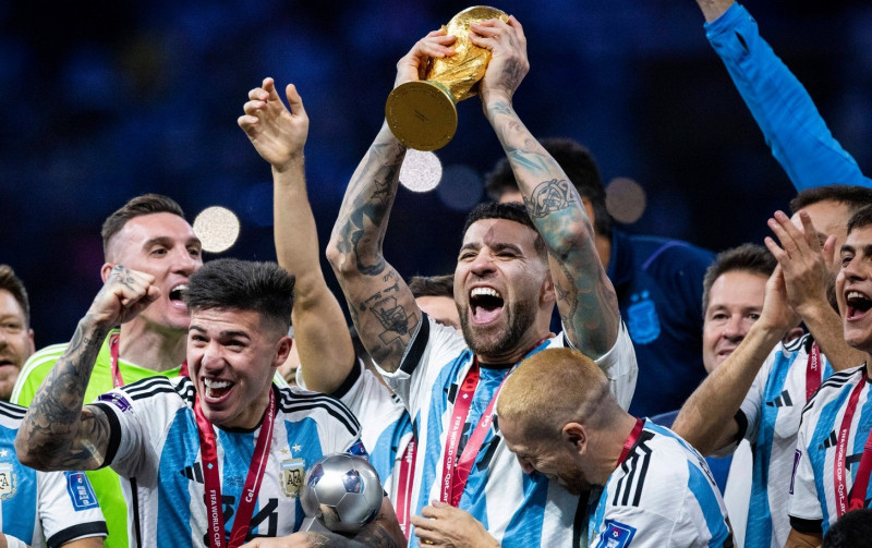 Doha, Qatar. 18th Dec, 2022. Enzo Fernandez (Arg), Nicolas Otamendi (Arg) lifts the FIFA World Cup, WM, Weltmeisterscha