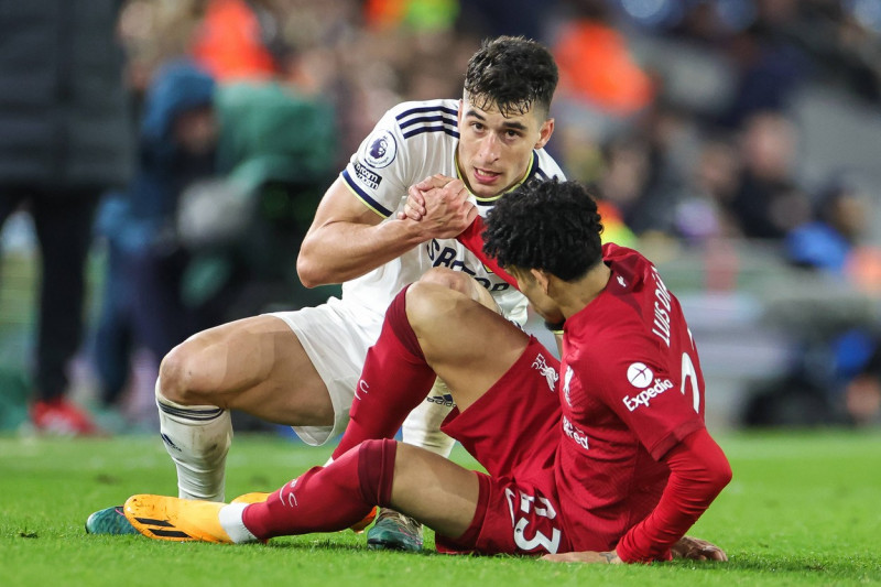 Premier League Leeds United v Liverpool Marc Roca 8 of Leeds United help Luis Diaz 23 of Liverpool after a challenge dur