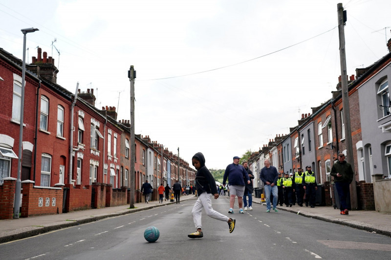 A child plays football outside of the stadium before the Sky Bet Championship play-off semi-final second leg match at Kenilworth Road, Luton. Picture date: Tuesday May 16, 2023.