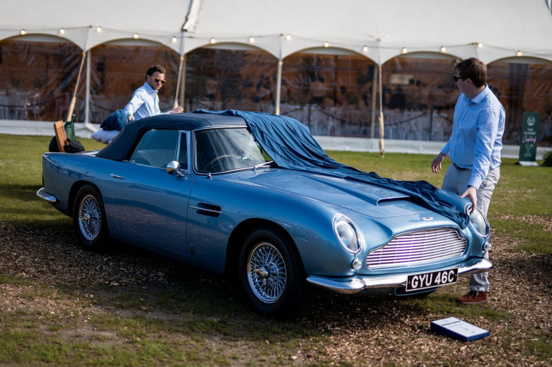The cover is removed from a 1965 Aston Martin DB5 convertible on display during the preview for Salon Prive London at the Royal Hospital Chelsea in London. Picture date: Thursday April 20, 2023.