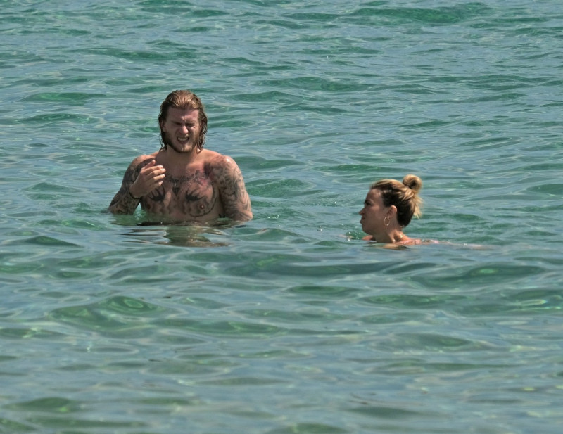 The Italian sports presenter Diletta Leotta showcases her ever-growing baby bump spotted out on the beaches of Ibiza with her beau, the Newcastle goalkeeper Loris Karius.