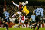 Dennis Bergkamp of Arsenal clashes with Ajax keeper Bogdan Lobont