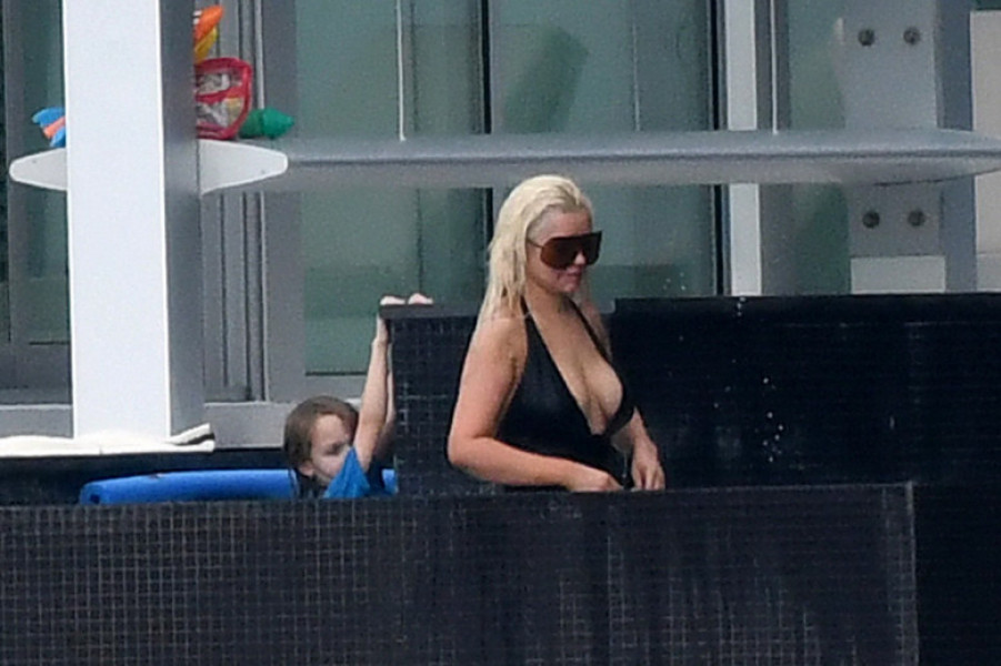 EXCLUSIVE: Christina Aguilera wears a black swimsuit and oversized sunglasses as she takes a dip in the pool between recording sessions in Miami