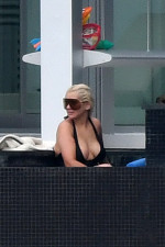 EXCLUSIVE: Christina Aguilera wears a black swimsuit and oversized sunglasses as she takes a dip in the pool between recording sessions in Miami