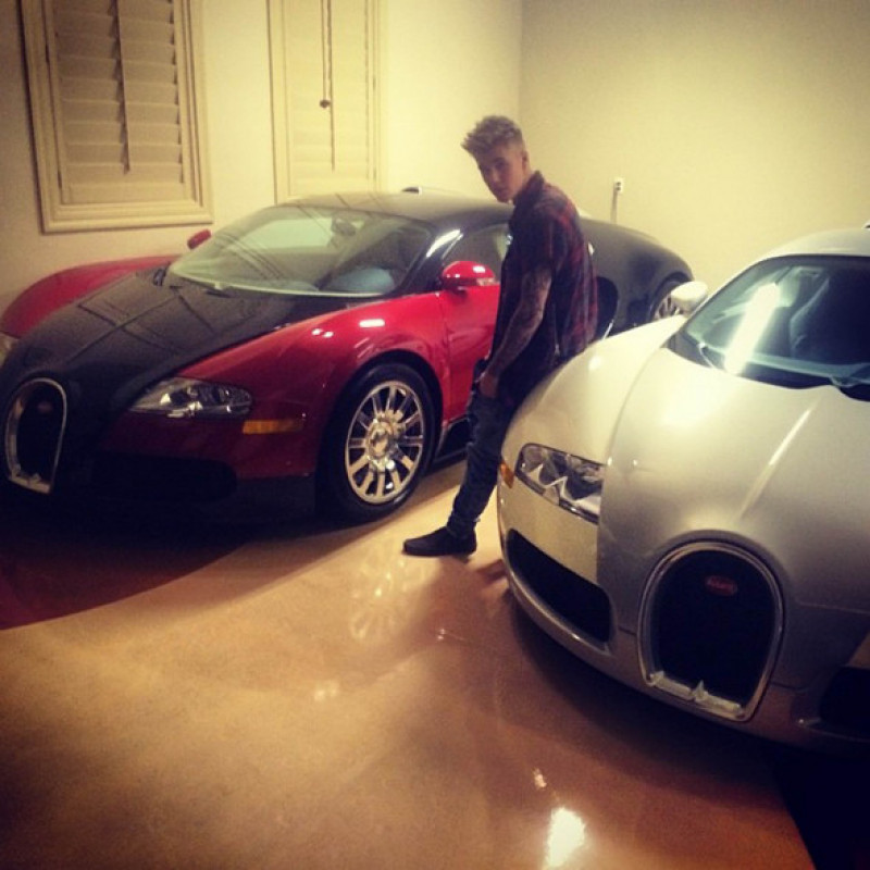 ustin Bieber poses with Bugatti Veyron cars