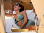 Singer Dua Lipa wears a black string bikini under a sheer knit coverup a she hits the beach in Miami
