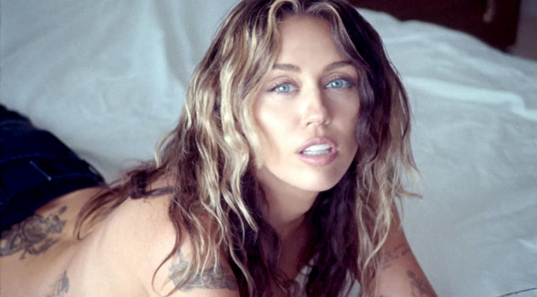 Miley Cyrus steams up the screen as she goes topless in new music video for latest single – the breakup ballad Jaded.