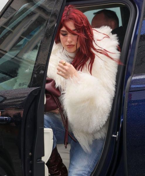 Dua Lipa looks chic wearing a fluffy coat and burgundy boots to match her hair at the Capital Radio Studios in London.