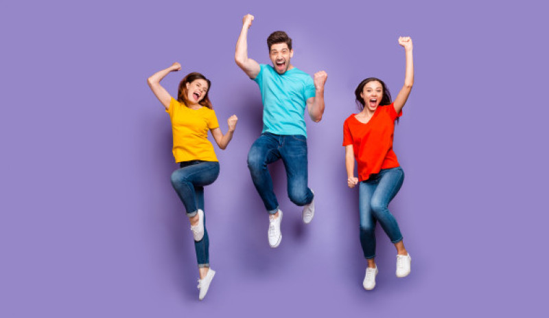 trei tineri care sar in sus de bucurie