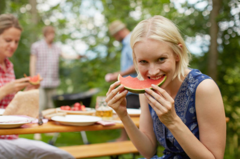 Woman eating watermelon outdoors