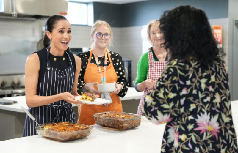 The Duchess of Sussex, alongside staff members, serves lunch to a resident during a visit to McAuley Community Services for Women, a women's homeless and family violence shelter in Footscray, in Melbourne, Victoria, on day one of the royal trip to Austral