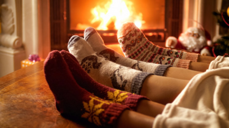 Closeup photo of family feet in woolen socks lying next to fireplace