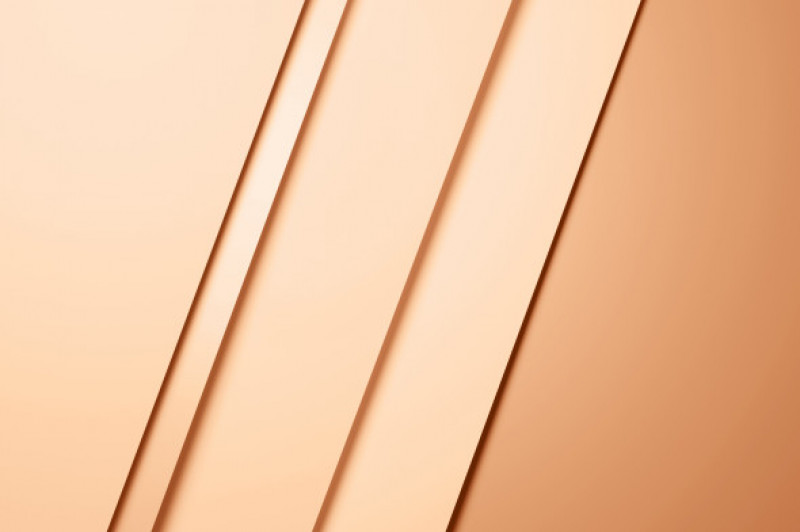 Background made of several layers of paper in trendy colors of the year: beige, pastel orange. Flat lay style. Demonstrating pantone Peach color - Peach Fuzz.