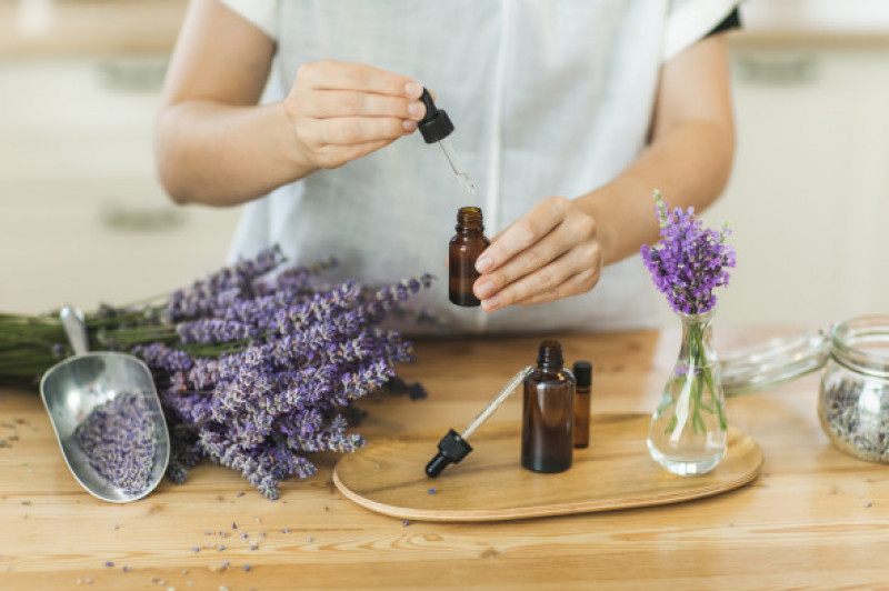 Woman hands holding pipette of essential lavender oil.