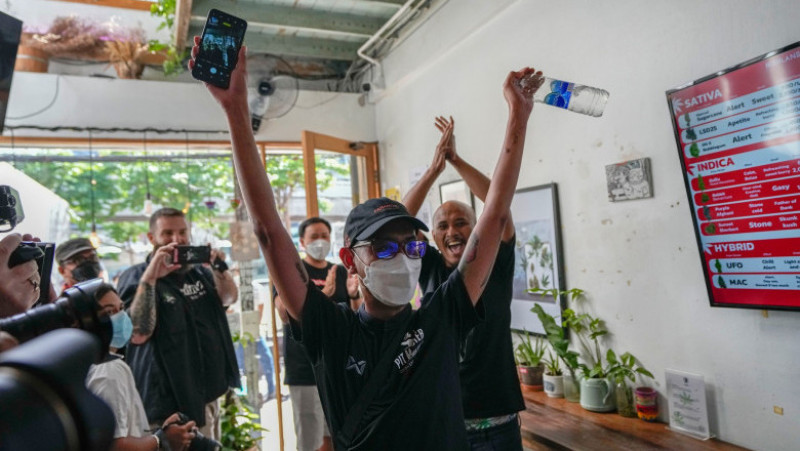 Primul client al unui comerciant din Bangkok sărbătorește după ce a cumpărat canabis legal în Thailanda. Foto: Profimedia Images