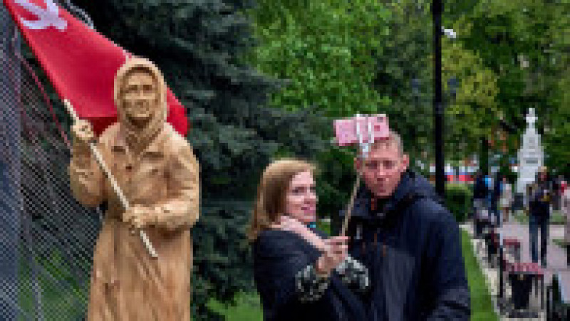 Un cuplu din Rusia care se fotografiază lângă o statue cu Babușka Z. Foto: Profimedia Images | Poza 15 din 16