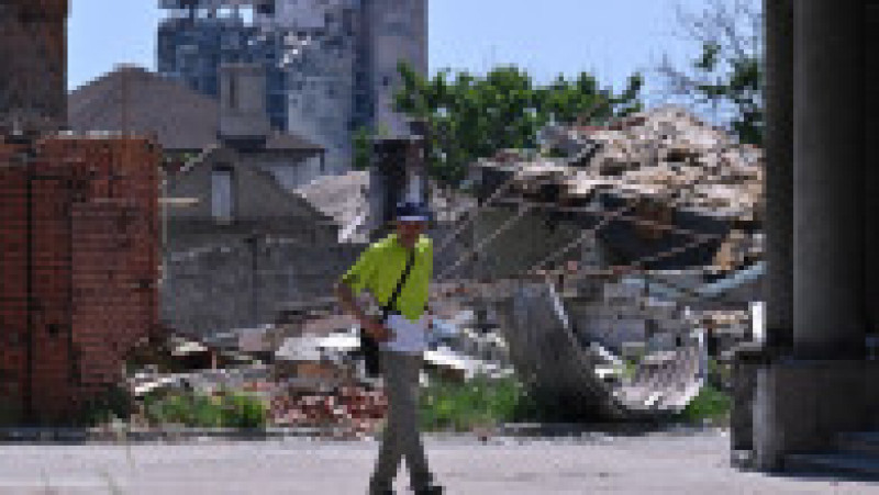 Un bărbat merge pe lângă ruinele provocate de bombardamentele rusești, în Mariupol. . Foto: Profimedia | Poza 6 din 8