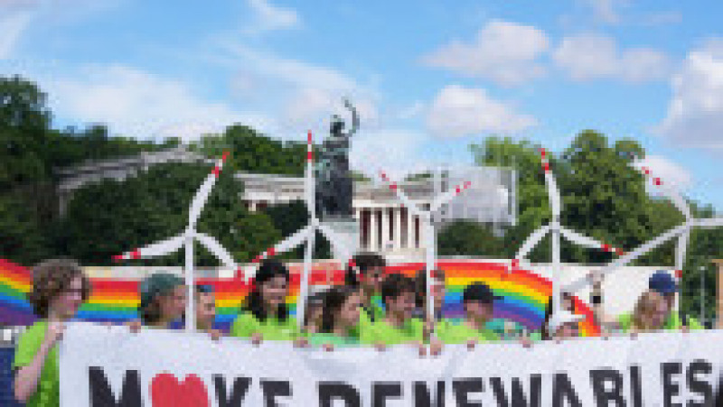 Protestatarii mărșăluiesc cu un banner și modele de mori de vânt în timpul unei demonstrații înaintea summitului G7 de la München. Foto: Profimedia Images | Poza 2 din 9