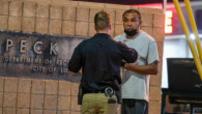 A police officer interviews a bystander near the scene of a shooting at Peck Park in San Pedro, Calif., Sunday, July 24, 2022.,Image: 709649581, License: Rights-managed, Restrictions: This content is intended for editorial use only. For other uses, additional clearances may be required., Model Release: no, Credit line: Profimedia | Poza 9 din 9