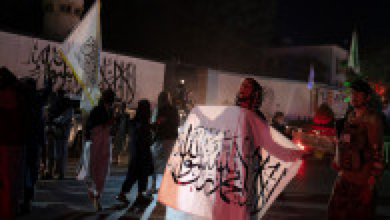 Noaptea trecută, focurile de armă au fost înlocuite cu focuri de artificii, care au strâns pe străzi sute de islamişti, care dansau înarmaţi pe fondul uralelor de victorie, a strigătelor de „Moarte Americii!” şi în timp ce fluturau steagul alb pe care era înscrisă Shahada, mărturisirea de credinţă în islam. Foto: Profimedia Images | Poza 4 din 17