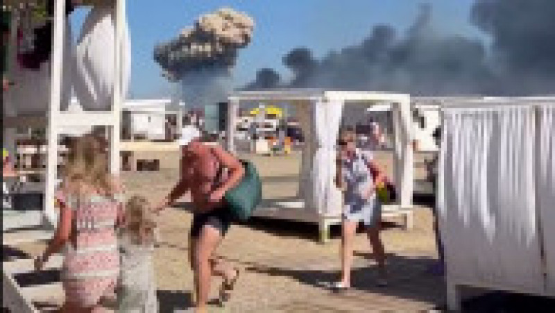 Turiștii ruși aflați pe plajă s-au speriat și au fugit când au văzut coloanele de fum după exploziile de la baza aeriană din Crimeea Foto: captură video Twitter | Poza 6 din 16